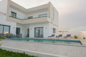 a villa with a swimming pool and a house at Villa Ghizen in Fafou