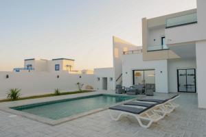 a villa with a swimming pool and a house at Villa Ghizen in Fafou