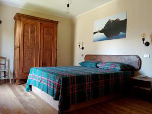 a bedroom with a bed with a plaid blanket at La Sosto de Cesi - B&B in Grange Pieccia