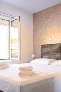 two beds in a white room with a window at Lighthouse Kotor in Prčanj