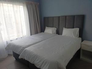 a bedroom with a large white bed with a window at Lifeshed Guest Home in Johannesburg