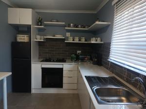 a kitchen with a sink and a black refrigerator at Lifeshed Guest Home in Johannesburg