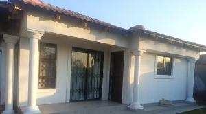 a white house with a porch with a gate at Lifeshed Guest Home in Johannesburg