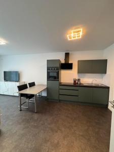 an empty kitchen with a table and a counter top at Luxuriöse Apartment in Bochum +10 photos