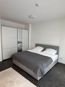 a bedroom with a large bed with white walls at Luxuriöse Apartment in Bochum