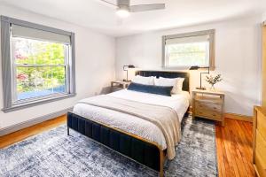 a bedroom with a large bed and two windows at Launchpoint Lodge in Lincoln