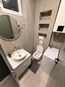 a bathroom with a sink and a toilet and a mirror at IK Apartments in Rake +30 photos