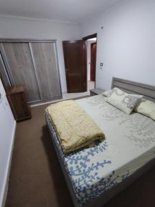 ein Schlafzimmer mit einem Bett mit einer blau-weißen Bettdecke in der Unterkunft ريماس 13 in Irbid