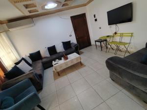 ein Wohnzimmer mit Sofa und Fernseher in der Unterkunft ريماس 13 in Irbid