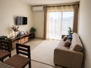 a living room with a couch and a large window at Apto de Paula in San Salvador