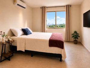 a bedroom with a bed and a large window at Apto de Paula in San Salvador