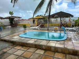 a pool with a water slide in a resort at Pousada Girassol Genipabu in Extremóz
