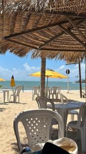 a group of chairs and tables on the beach at Pousada Girassol Genipabu in Extremóz