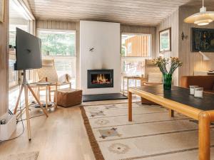 a living room with a table and a fireplace at 5 star holiday home in Væggerløse in Bøtø By +39 photos