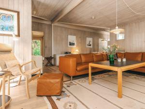 a living room with a couch and a table at 5 star holiday home in Væggerløse in Bøtø By