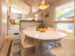 a kitchen and dining room with a white table and chairs at 5 star holiday home in Væggerløse in Bøtø By