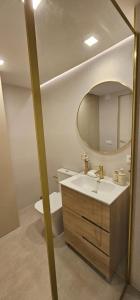 a bathroom with a sink and a toilet and a mirror at SeaFront Horizon in Sitio de Calahonda