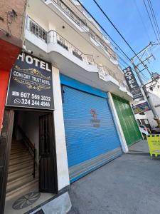a store with a blue garage door on a building at ConfortTrust Hotel in Ocaña