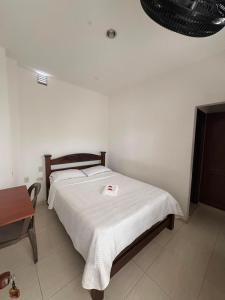 a bedroom with a bed with a white blanket on it at ConfortTrust Hotel in Ocaña
