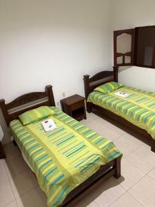 two beds sitting next to each other in a room at ConfortTrust Hotel in Ocaña