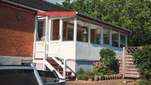 a screened in porch of a house with stairs at Amazing villa with garden in Kolding