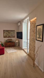 a living room with a stone wall and a red couch at CasaLù in Lanciano