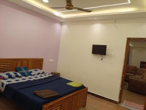 a bedroom with a bed and a flat screen tv at white sand villa in Tirupporūr
