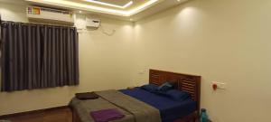 a bedroom with a bed and a air conditioner at white sand villa in Tirupporūr