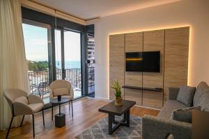 a living room with a couch and a television at Hana boutique apartments in Ulcinj