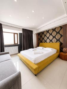 a bedroom with a large bed and a couch at PENTHOUSE GROUP 4 Apartments in Bucharest