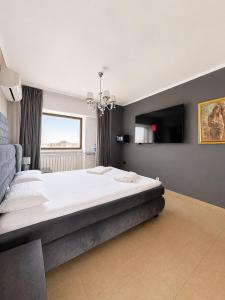 a bedroom with a large bed and a television at PENTHOUSE GROUP 4 Apartments in Bucharest