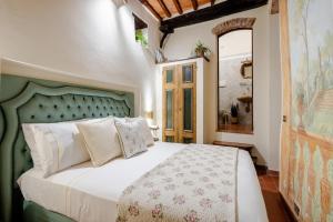 a bedroom with a bed with a green headboard at Arezzo Centre, Prestigious Apartment with a View in Arezzo
