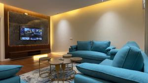 a living room with blue couches and a tv at شقق احد رفيدة in Ahad Rafidah