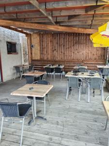 a patio with tables and chairs in a restaurant at L'Embaradere in Laruns