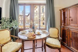 a dining room with a table and chairs and a window at Arezzo Centre, Prestigious Apartment with a View in Arezzo