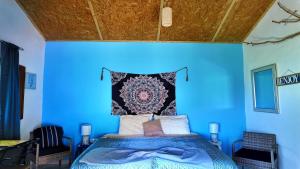 a blue bedroom with a bed with a blue wall at Casa Velho 05 Rodrigues in Órgãos +9 photos
