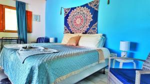 a blue bedroom with a bed and a blue wall at Casa Velho 05 Rodrigues in Órgãos