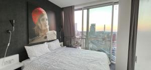 a bedroom with a bed and a painting of a woman at Om calmness in Birmingham
