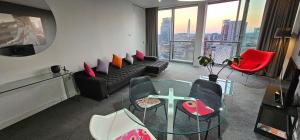 a living room with a glass table and red chairs at Om calmness in Birmingham