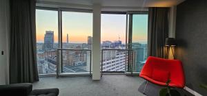 a room with a red chair in front of a large window at Om calmness in Birmingham