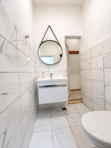a white bathroom with a sink and a mirror at Banićević APARTMANI in Đenovići +66 photos