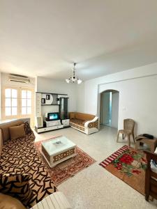 a living room with a couch and a table at Appartement près de la corniche in Sousse
