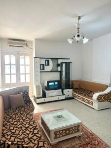 a living room with a couch and a coffee table at Appartement près de la corniche in Sousse
