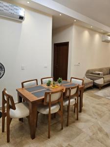 a dining room with a wooden table and chairs at Modern Hotel-Style Apartment in El Alamein