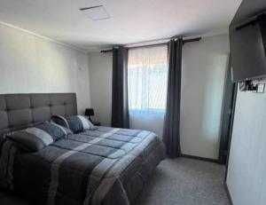 a bedroom with a bed and a large window at Hipolito in La Serena