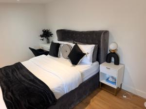 a bed with a black headboard in a bedroom at Gatwick LUXURY STUDIO FLAT in Crawley