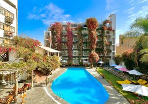 a hotel with a swimming pool in front of a building at Hotel Sol de Ica in Ica