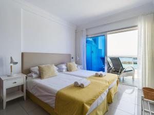 two beds in a bedroom with a view of the ocean at HolaMogamar in Puerto de Mogán