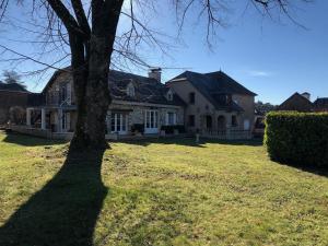 a large house with a tree in the yard at La Chouette in Beynat