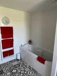 a bathroom with a white tub and red towels at La Chouette in Beynat +26 photos